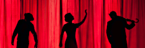 Silhouettes against a red curtain.